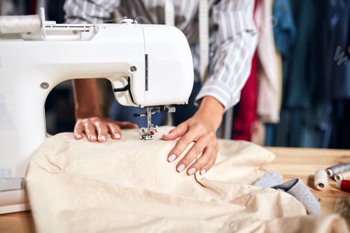 Preview: close up cropped photo. tailor mending cusstomer's clothing