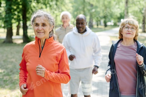 Preview: Senior woman running with her friends outdoors