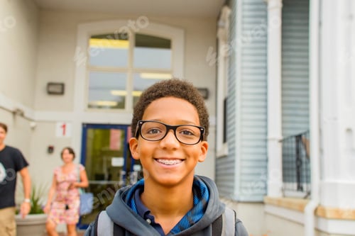 Preview: Happy boy standing in front of school