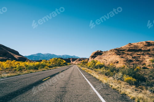 Preview: Empty route running away through rocky terrain