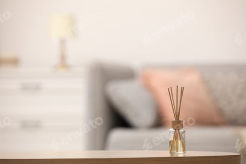 Preview: Reed air freshener with essential oil on table indoors. Space for text