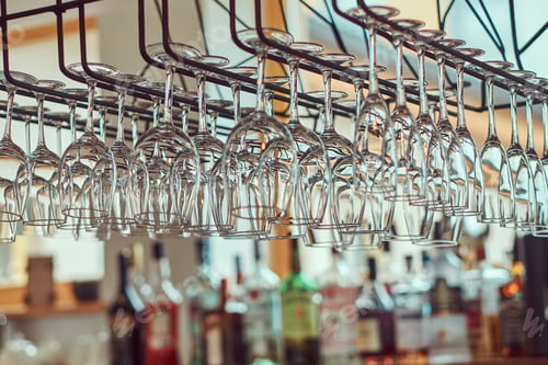 Preview: Close-up image of a wine glasses hanging in the bar above the bar counter.