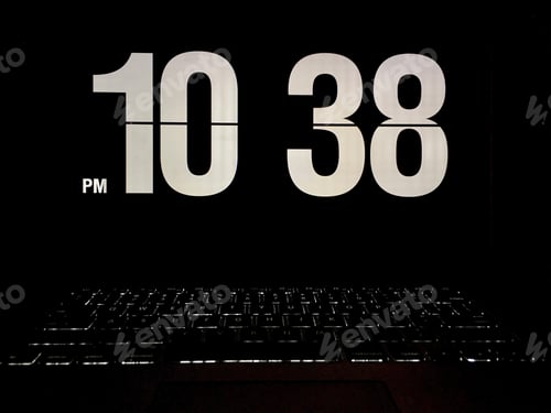 Preview: Working late. Laptop computer with illuminated keyboard and cool retro clock app