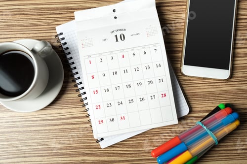 Preview: Planning for October with a coffee, colorful markers, and a smartphone on a wooden desk