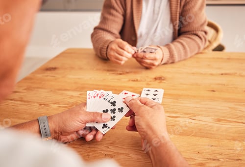 Preview: Hands, cards and a senior man playing a game at a table in the living room of a retirement home. Th