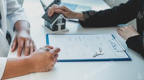 Preview: Hand signing on contract after the real estate agent explains the business contract