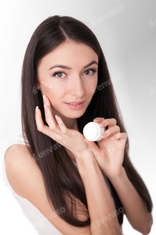 Preview: Beautiful Woman Applying Face Cream in Studio Shot