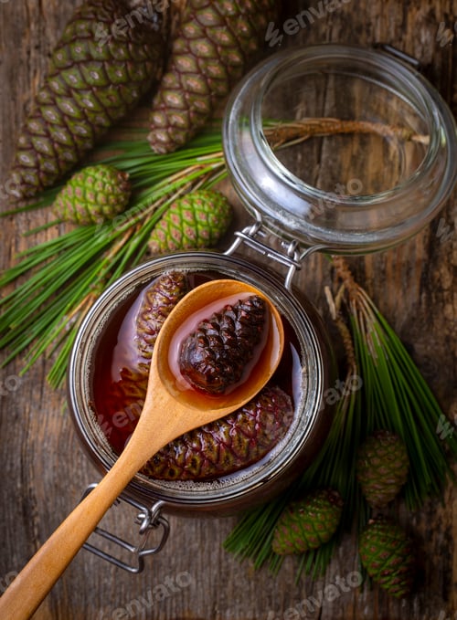 Preview: Young pine cones jam in glass bowl on wooden board. Delicious jam with the little pine cones.