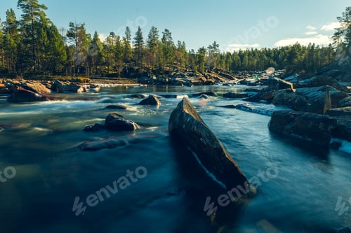 Preview: Beautiful horizontal shot of a river with a lot of rocks surrounded by green-leafed trees