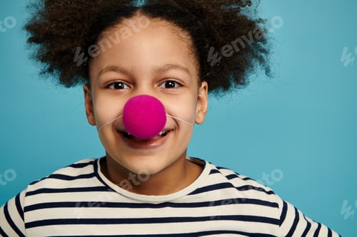 Vista previa: A girls playful smile with a clown nose