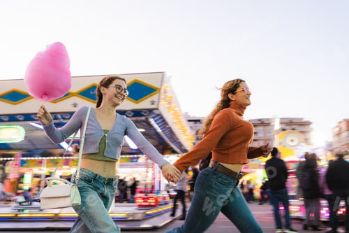 Preview: Friends enjoying fun fair ride with cotton candy