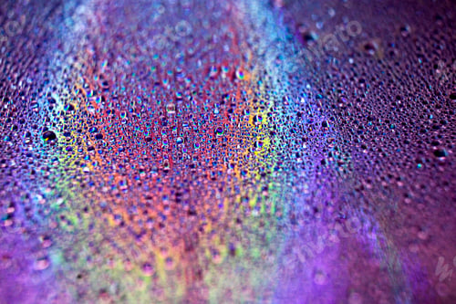 Preview: Selective focus shot of colorful reflective water drops on a digital disc surface