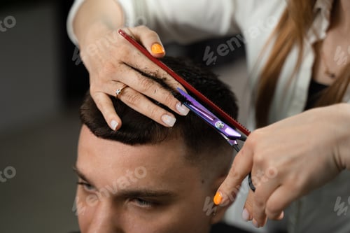 Preview: Woman barber creating precise haircut for male client