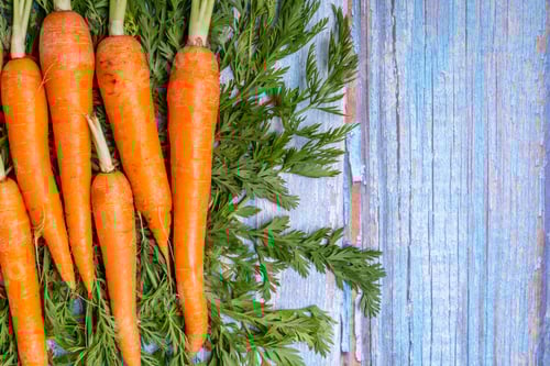 Preview: Top view of fresh raw carrots on a wooden table