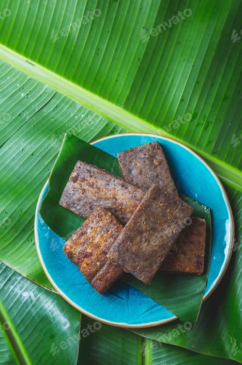 Preview: Easter Island Tahitian Polynesian banana pie pupping POE on blue plate on banana palm tree leaves.