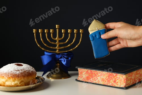 Preview: Hanukkiah, donut and gingerbread in hand on black background