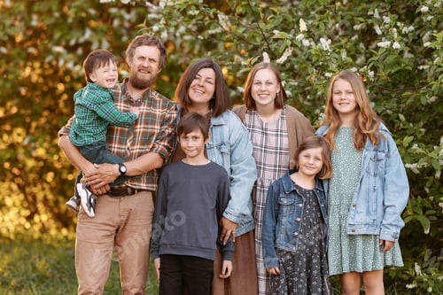 Preview: Large friendly family in the summer on the field.