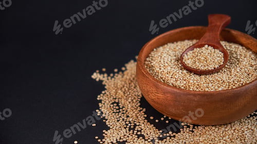 Preview: quinoa in bowl and a spoon on kitchen table top view.