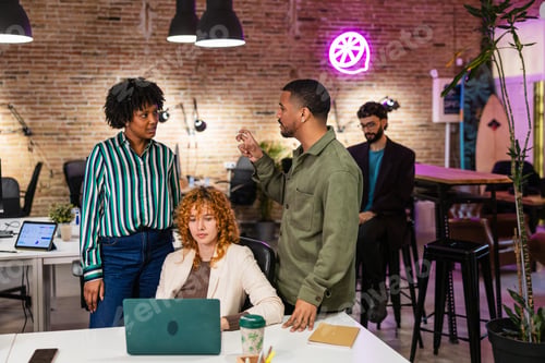 Preview: Marketing team discussing new project on laptop in modern office