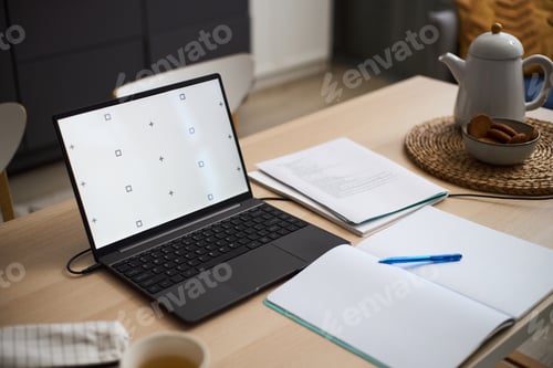 Preview: Open Laptop with Documents and Notebook on Table in Home Office Setting
