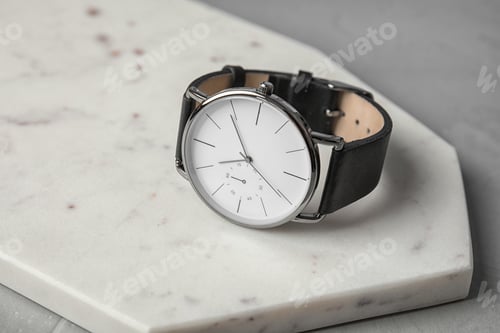 Preview: Board with stylish wrist watch on gray table. Fashion accessory