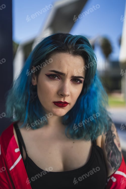 Preview: Shallow focus of a beautiful and attractive woman with blue hair and blood-red lipstick