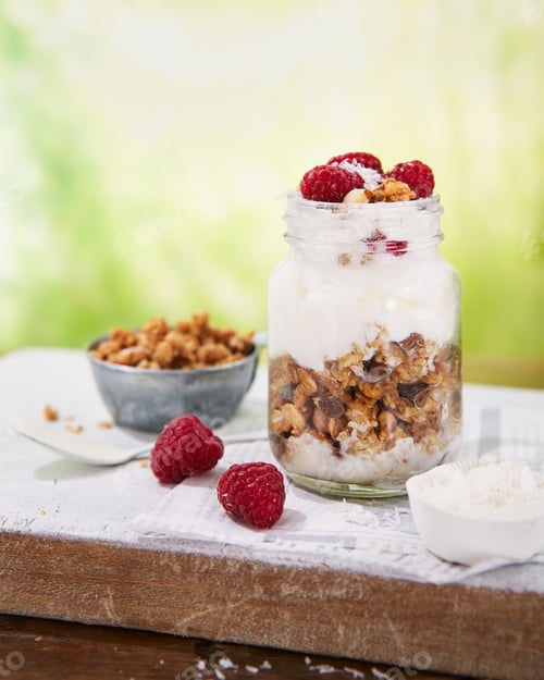 Preview: Granola with greek yogurt parfait fresh raspberries, coconut in a glass.
