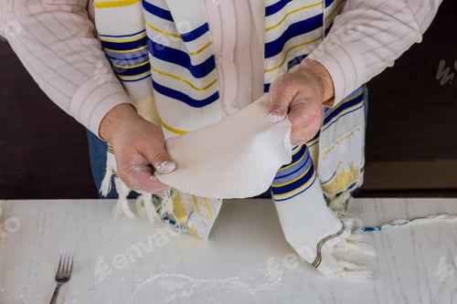 Preview: Orthodox Jewish man prepare for the Jewish holiday day in hand made flat kosher matzah prepare