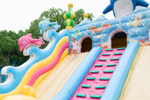 Girl Sliding Down Inflatable Bouncy Castle Slide