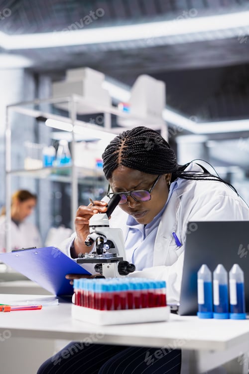 Preview: Woman in lab checking product surface for tiny defects using microscope lens