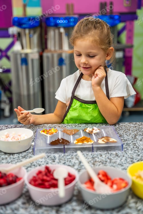 Preview: Little girl learning how to cook in a cooking class. Handmade dessert. Making chocolate candy, Child