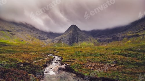 Preview: Moody landscape view of Cuillin hills with river in foreground, Scotland