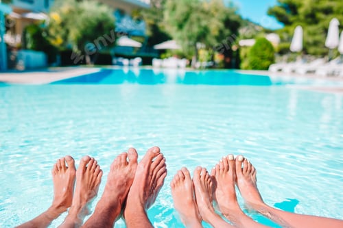 Preview: Close up of four people's legs by pool side