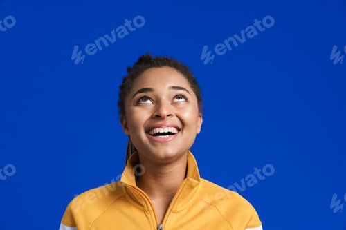 Preview: Black young woman smiling while looking upward