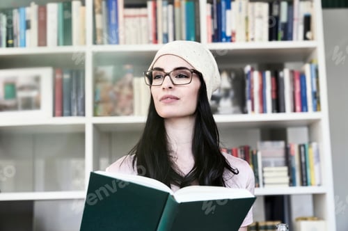 Preview: Young woman holding book looking sideways