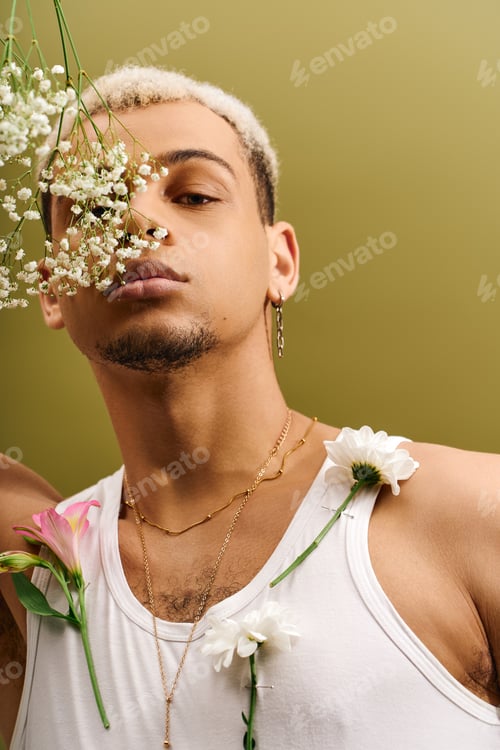 Preview: Trendy young man with dyed hair showcases floral fashion in a vibrant studio setting