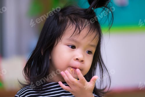 Preview: Closeup cute girl using her hand to eat dessert called Foi Thong.