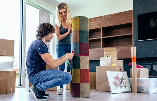 Couple Unpacking Rug in New Home Together