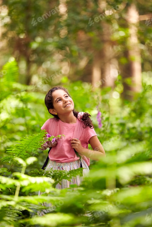 Preview: Smiling Girl Walking In Summer Woodland Surrounded By Ferns Wearing Backpack