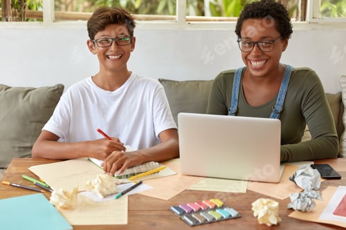 Preview: Mixed race students of high school learn together at coworking space, watch training webinar on lapt