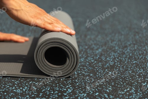 Preview: Man hands unrolling yoga mat before practice at sports ground. Outdoor.