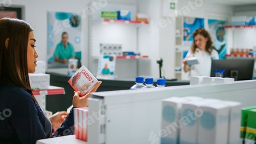 Preview: Asian client holding cardiology pills in box to buy healthcare medicine