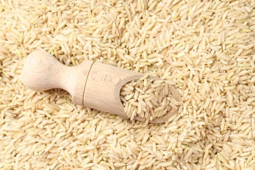 Preview: Pile of brown rice with wooden scoop, top view