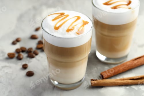 Preview: Tasty latte macchiato in glasses, coffee beans and cinnamon on grey table, closeup