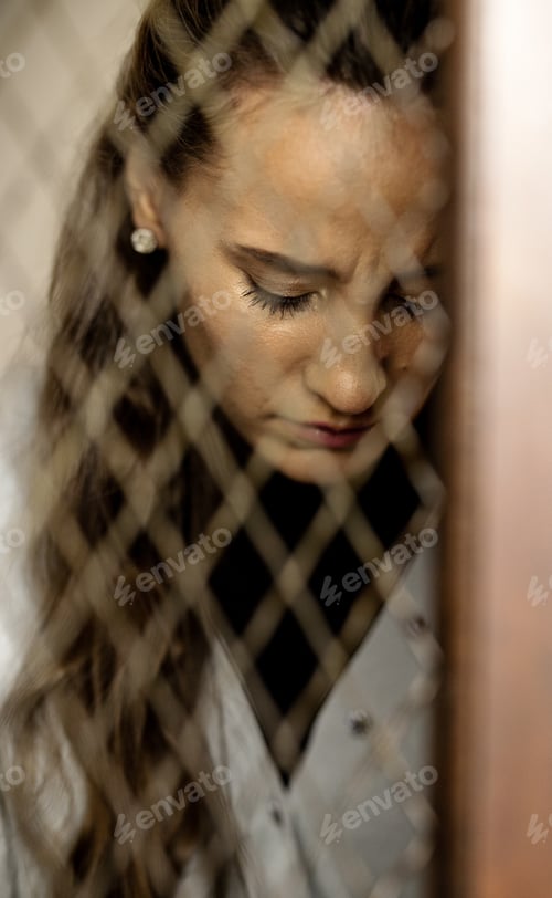 Preview: Depression, sadness and abuse with a woman behind a cage as a slave or prisoner of violence. Jail,