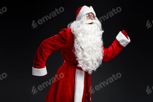 Preview: Santa Claus running, hurry up isolated on black background. Holidays, advertisement concept
