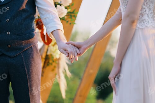 Preview: Man and woman hand hold together at wedding ceremony outdoor