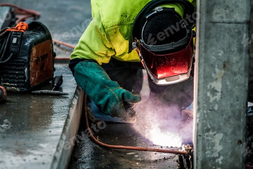 Preview: Closeup of a construction worker using a flame torch to cut up heavy machinery