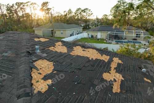 Preview: Damaged house roof with missing shingles after hurricane Ian in Florida