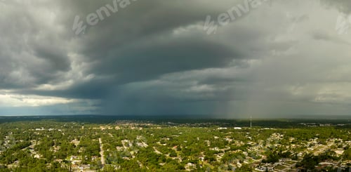 Preview: Dark stormy clouds forming on gloomy sky before heavy rainfall over suburban town area